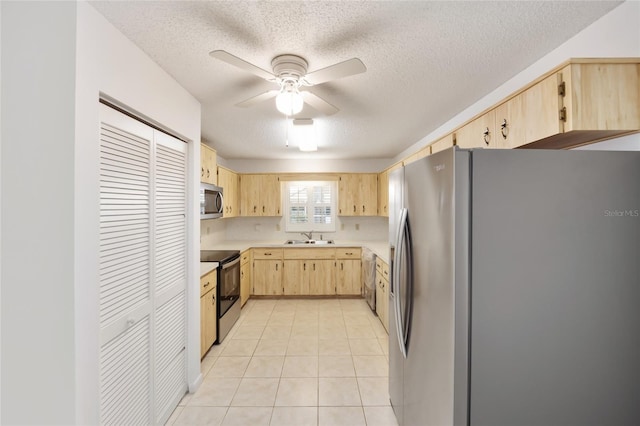 kitchen with sink, light tile patterned floors, stainless steel appliances, and light brown cabinetry