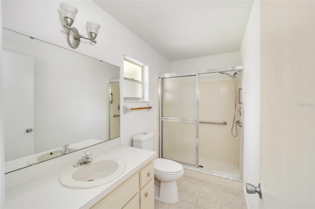 bathroom with vanity, tile patterned flooring, toilet, a textured ceiling, and an enclosed shower