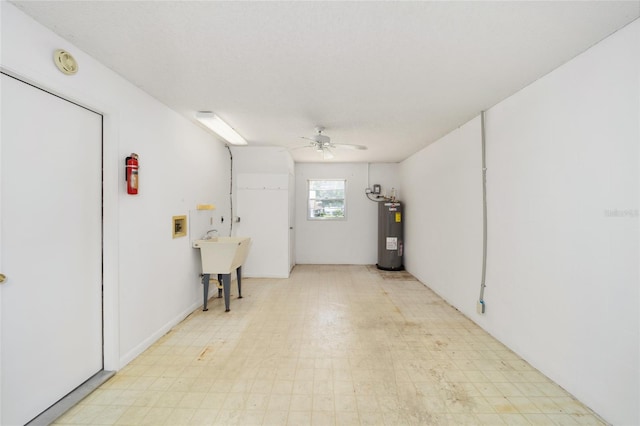 garage featuring electric water heater, sink, and ceiling fan