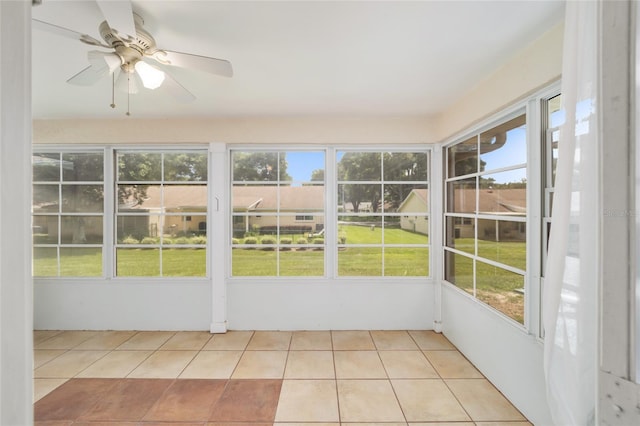 unfurnished sunroom featuring ceiling fan