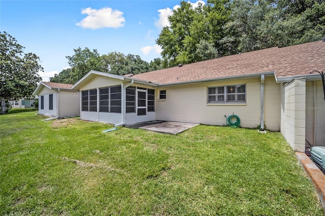 rear view of property featuring a sunroom, a patio area, and a yard