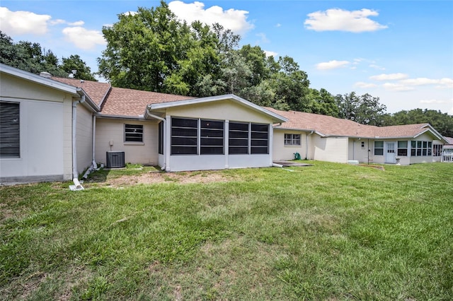 back of property featuring central AC and a yard