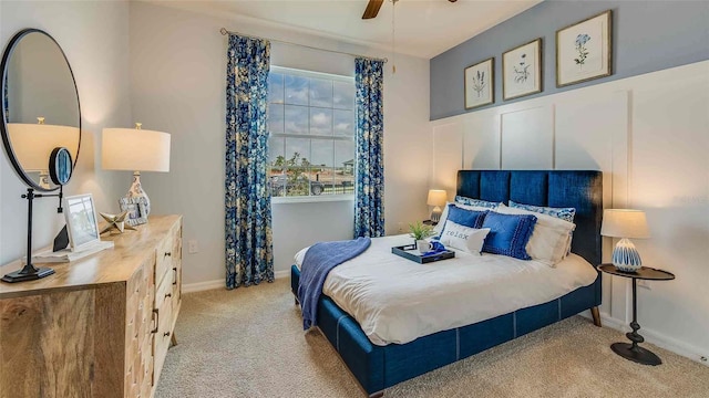 bedroom featuring carpet floors, baseboards, and a decorative wall