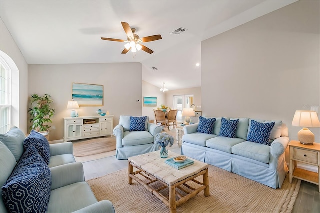 living room with ceiling fan, light hardwood / wood-style flooring, and vaulted ceiling