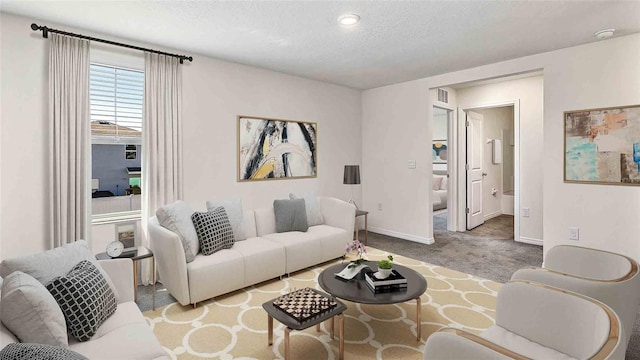 living room featuring light colored carpet and a textured ceiling