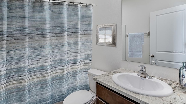 bathroom featuring a shower with curtain, vanity, and toilet