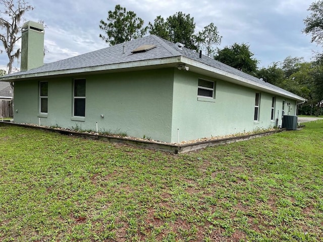 view of side of home featuring a lawn and cooling unit