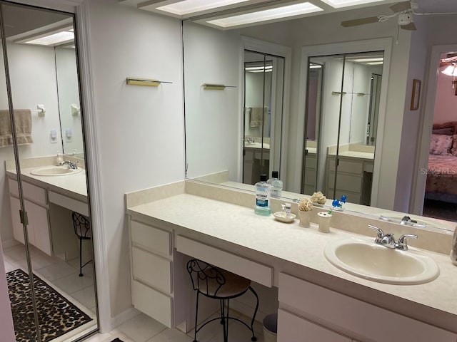 bathroom with tile patterned flooring, vanity, and ceiling fan