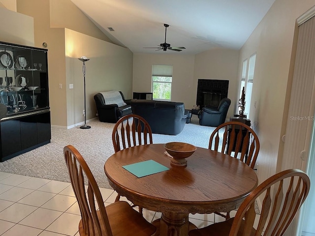 dining room with light carpet, vaulted ceiling, and ceiling fan