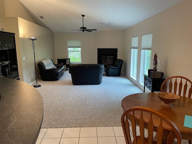 living room featuring ceiling fan, light colored carpet, and vaulted ceiling