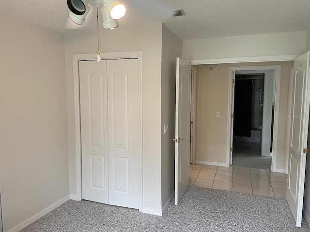 unfurnished bedroom with light carpet, a closet, and ceiling fan