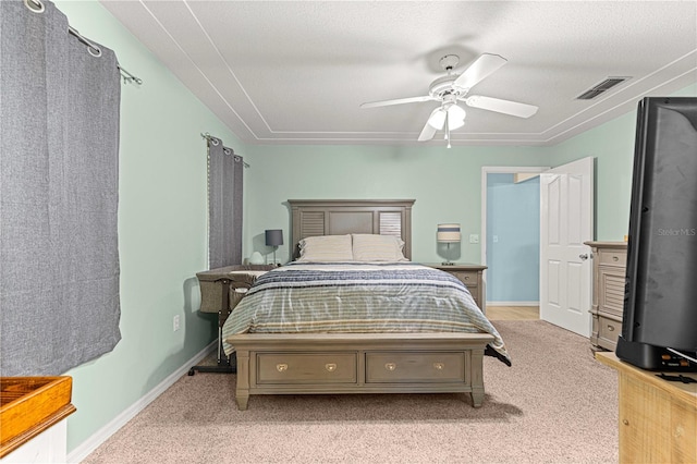 bedroom with ceiling fan, light colored carpet, and a textured ceiling