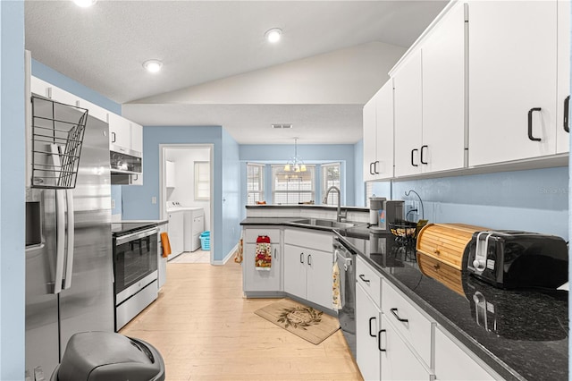 kitchen with sink, decorative light fixtures, vaulted ceiling, white cabinets, and appliances with stainless steel finishes