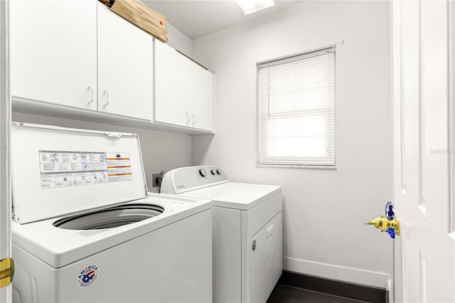 washroom featuring washer and clothes dryer, cabinets, and a textured ceiling