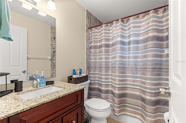 bathroom with vanity, toilet, and a textured ceiling