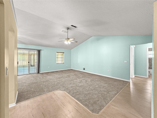 unfurnished living room featuring a textured ceiling, a ceiling fan, baseboards, lofted ceiling, and visible vents