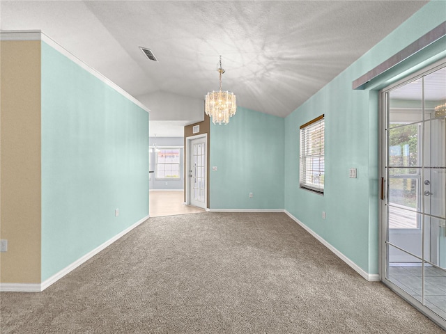 carpeted spare room featuring vaulted ceiling, a chandelier, a wealth of natural light, and visible vents