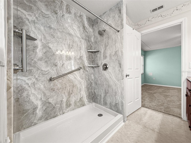 bathroom featuring a marble finish shower, baseboards, vanity, and visible vents
