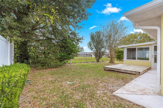 view of yard featuring a wooden deck and fence
