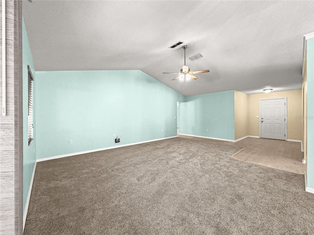 interior space with vaulted ceiling, carpet, visible vents, and a ceiling fan