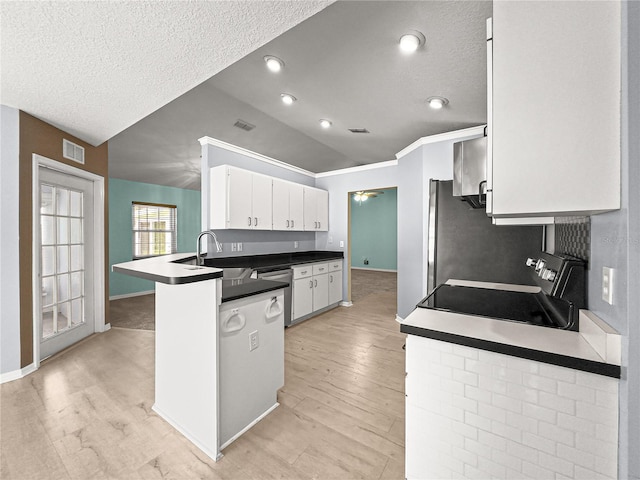 kitchen with a textured ceiling, stainless steel appliances, visible vents, and a sink