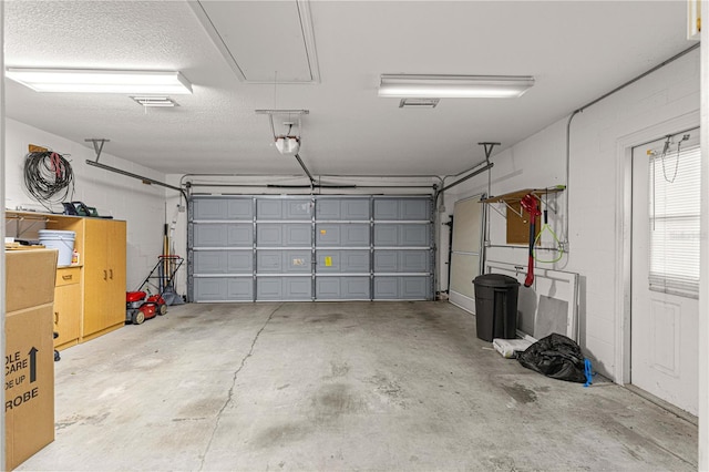 garage with a garage door opener and concrete block wall