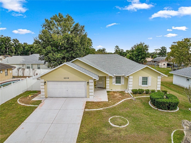 ranch-style home featuring a garage, fence, driveway, and a front yard