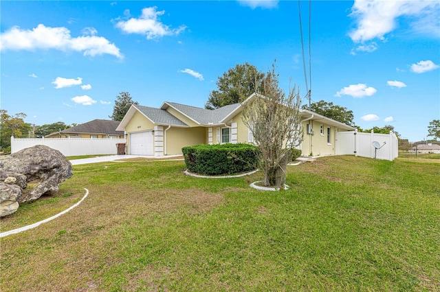 ranch-style house featuring a garage, fence, a front yard, and concrete driveway