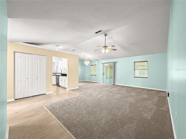unfurnished living room with vaulted ceiling, baseboards, a ceiling fan, and visible vents