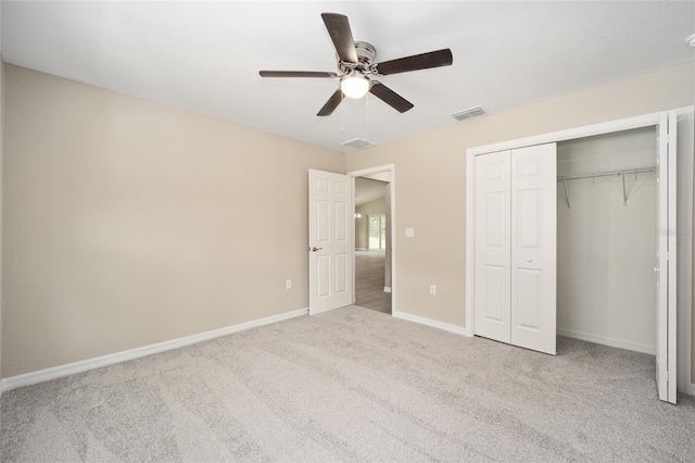 unfurnished bedroom with ceiling fan, light colored carpet, and a closet