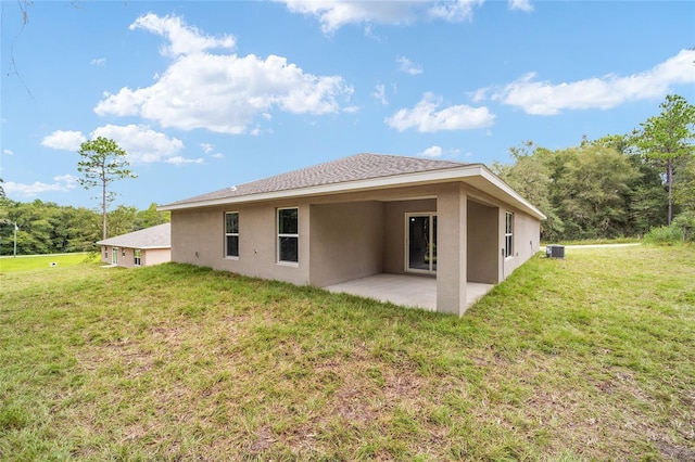 rear view of property featuring central AC unit, a patio area, and a lawn