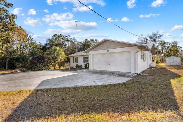 view of side of property featuring a shed, a garage, and a lawn