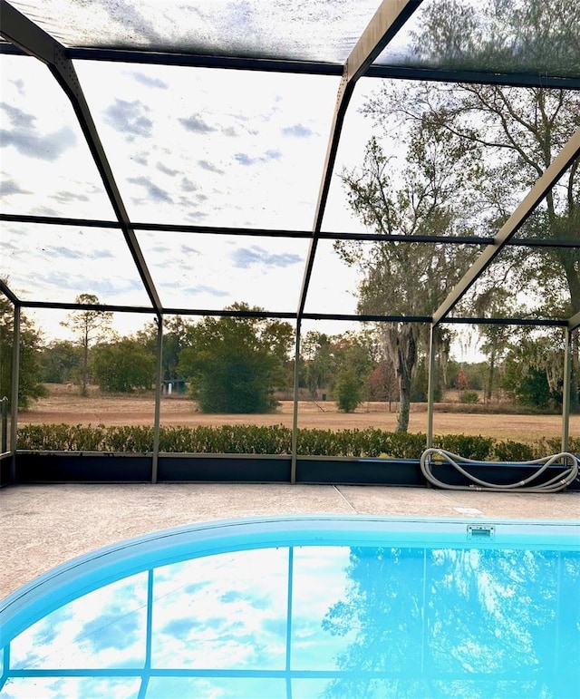 view of pool featuring glass enclosure