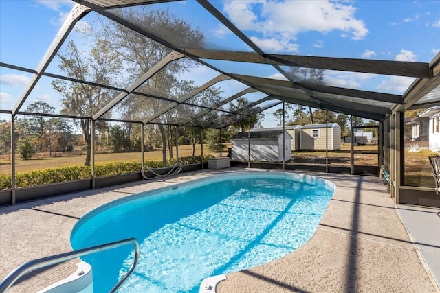 view of swimming pool with a patio, a shed, and a lanai