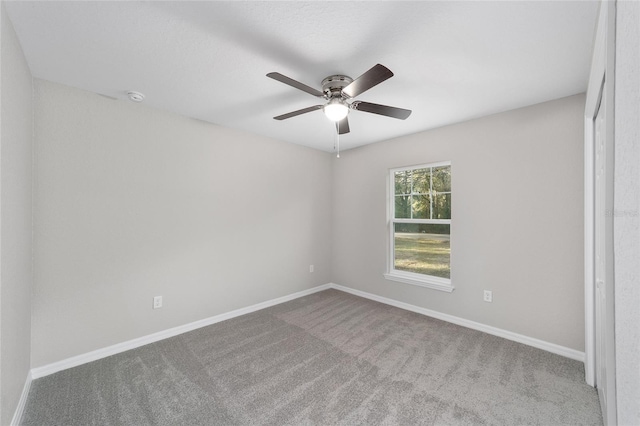 unfurnished room with ceiling fan and carpet flooring