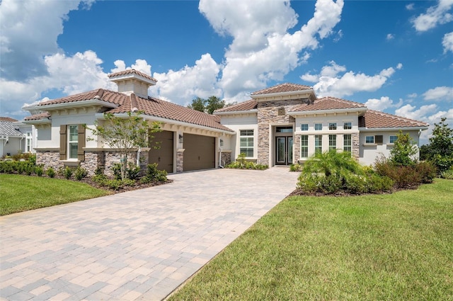 mediterranean / spanish home with a front lawn and a garage