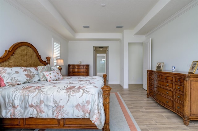 bedroom with ornamental molding and light wood-type flooring