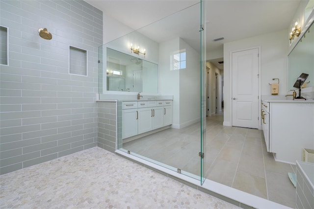 bathroom with tile patterned floors, vanity, tile walls, and walk in shower