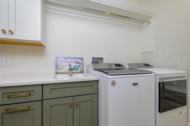 laundry area with washer and clothes dryer, cabinets, and sink