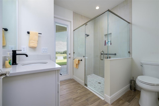 bathroom with vanity, hardwood / wood-style flooring, toilet, and an enclosed shower