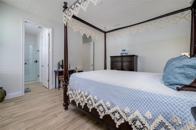 bedroom featuring ensuite bath and light wood-type flooring