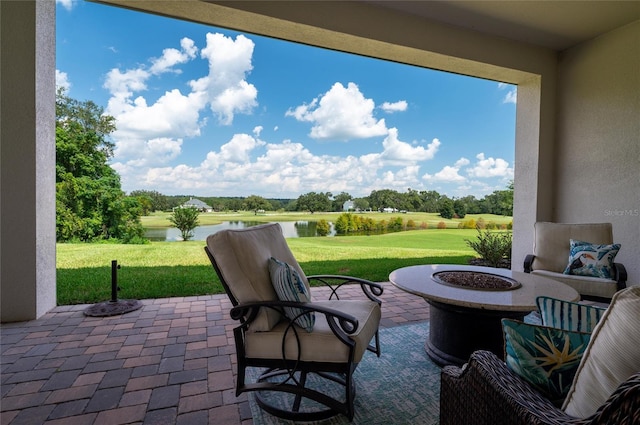 view of patio with a water view and an outdoor fire pit