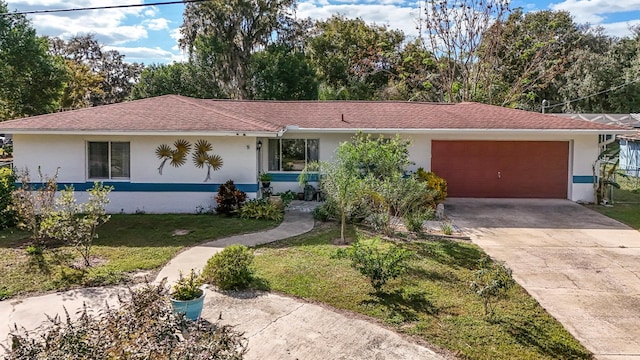 ranch-style home featuring a garage and a front lawn