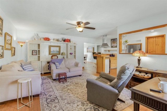 living room with light hardwood / wood-style floors and ceiling fan