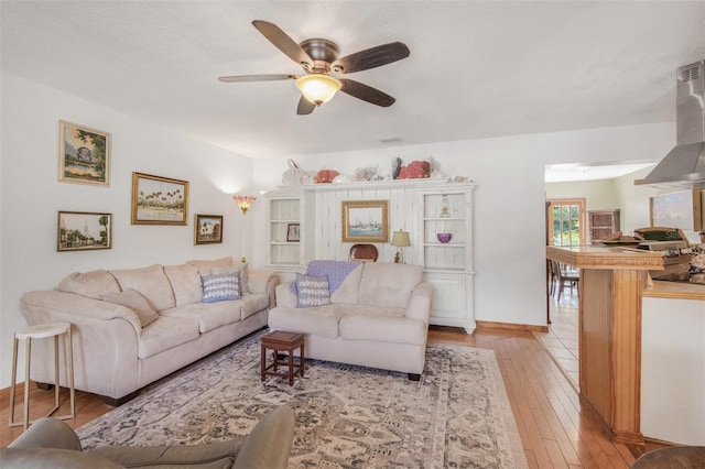 living room with ceiling fan and light wood-type flooring