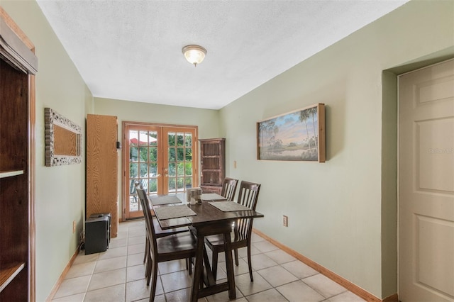 tiled dining area featuring vaulted ceiling, a textured ceiling, and french doors