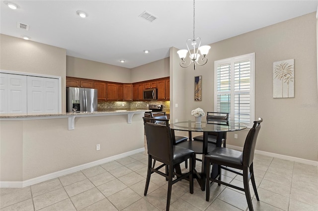 dining space with light tile patterned floors and a chandelier