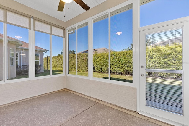 unfurnished sunroom featuring ceiling fan