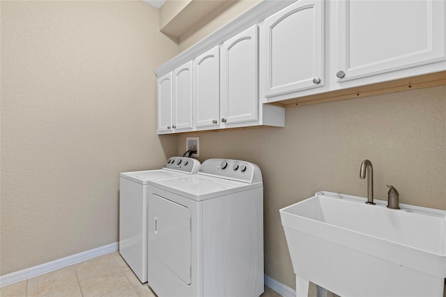 laundry area featuring washer and dryer, sink, light tile patterned floors, and cabinets