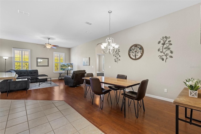 dining area with ceiling fan with notable chandelier and light hardwood / wood-style flooring